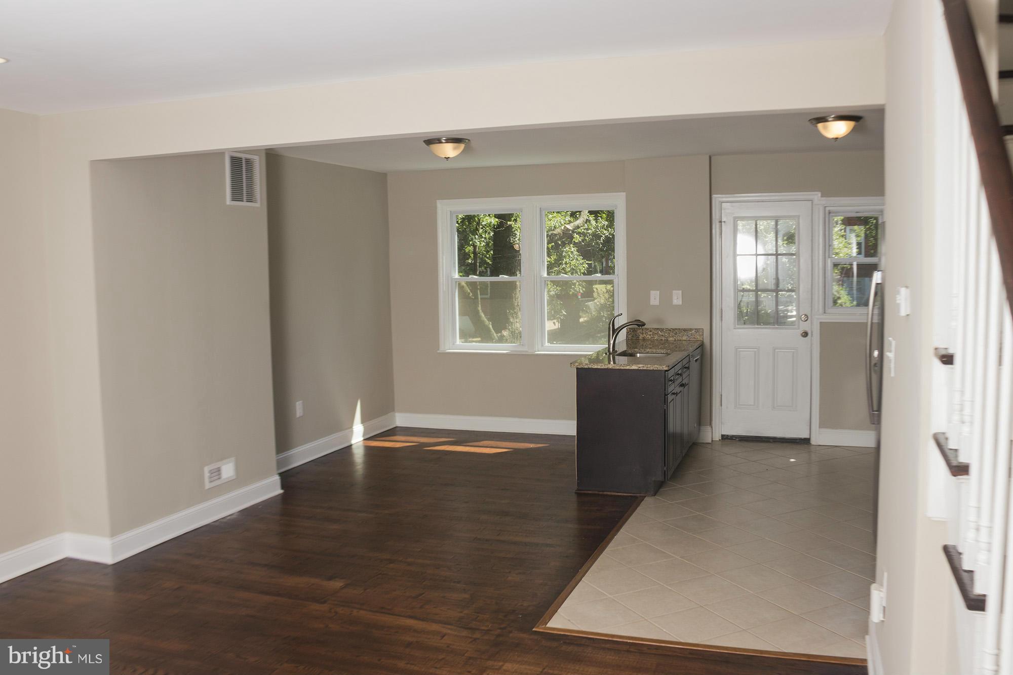 1021 Upnor Road Baltimore, MD 21212 - Photo 9 of 24 an empty room with wooden floor and windows