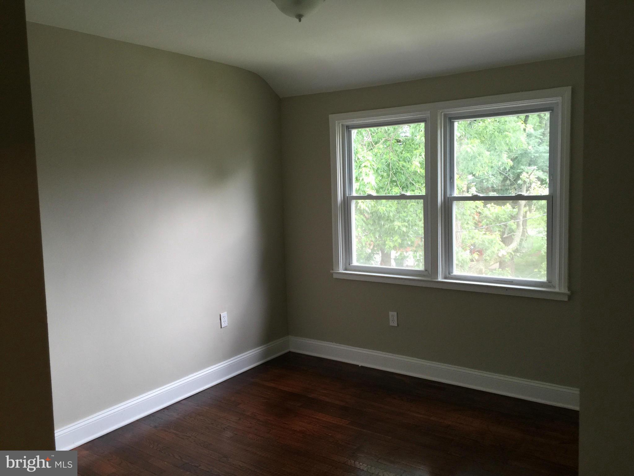 1021 Upnor Road Baltimore, MD 21212 - Photo 10 of 24 an empty room with wooden floor and windows