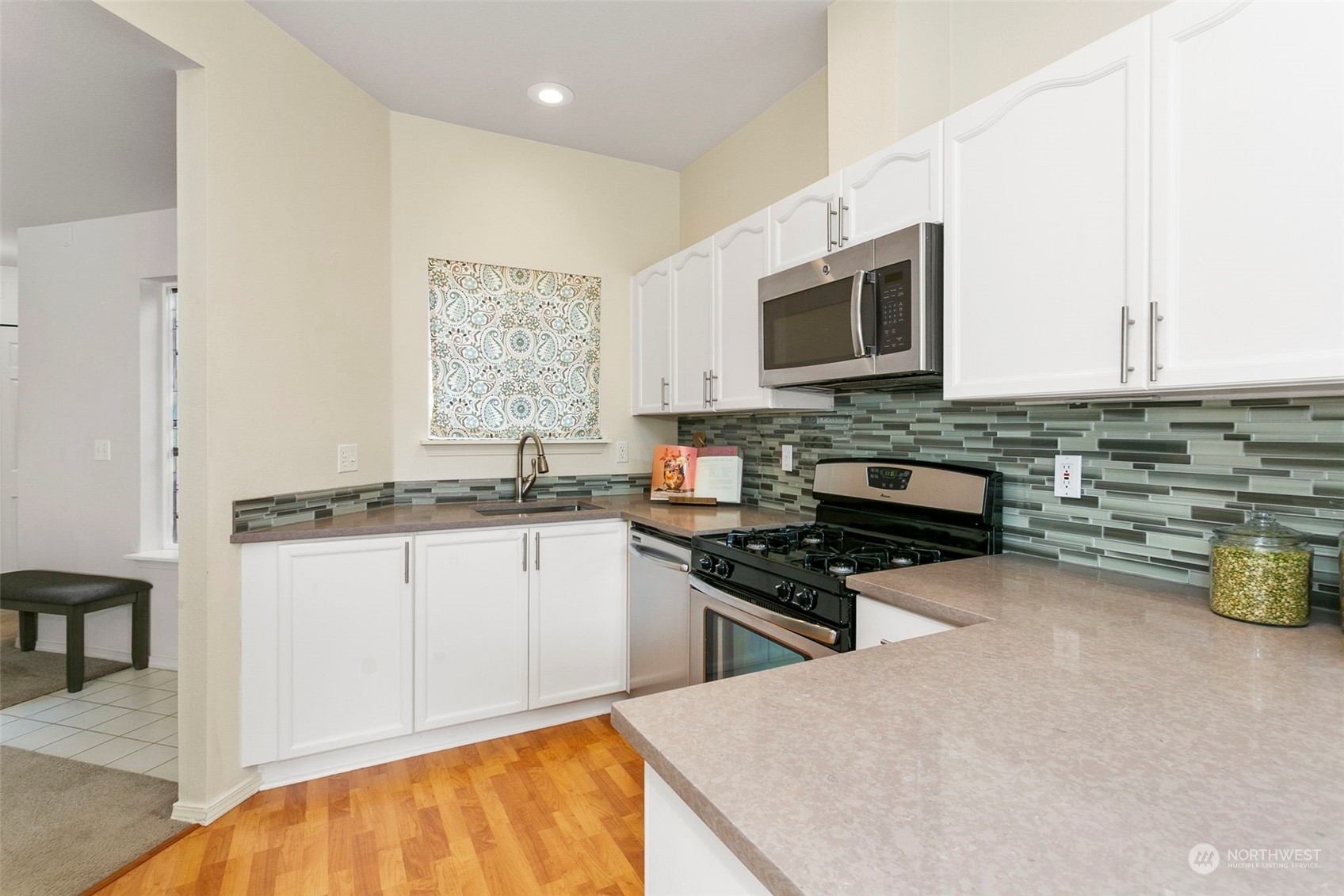 22619 4th Avenue West, Unit 104 Bothell, WA 98021 - Photo 5 of 19 a kitchen with stainless steel appliances a stove sink microwave and cabinets