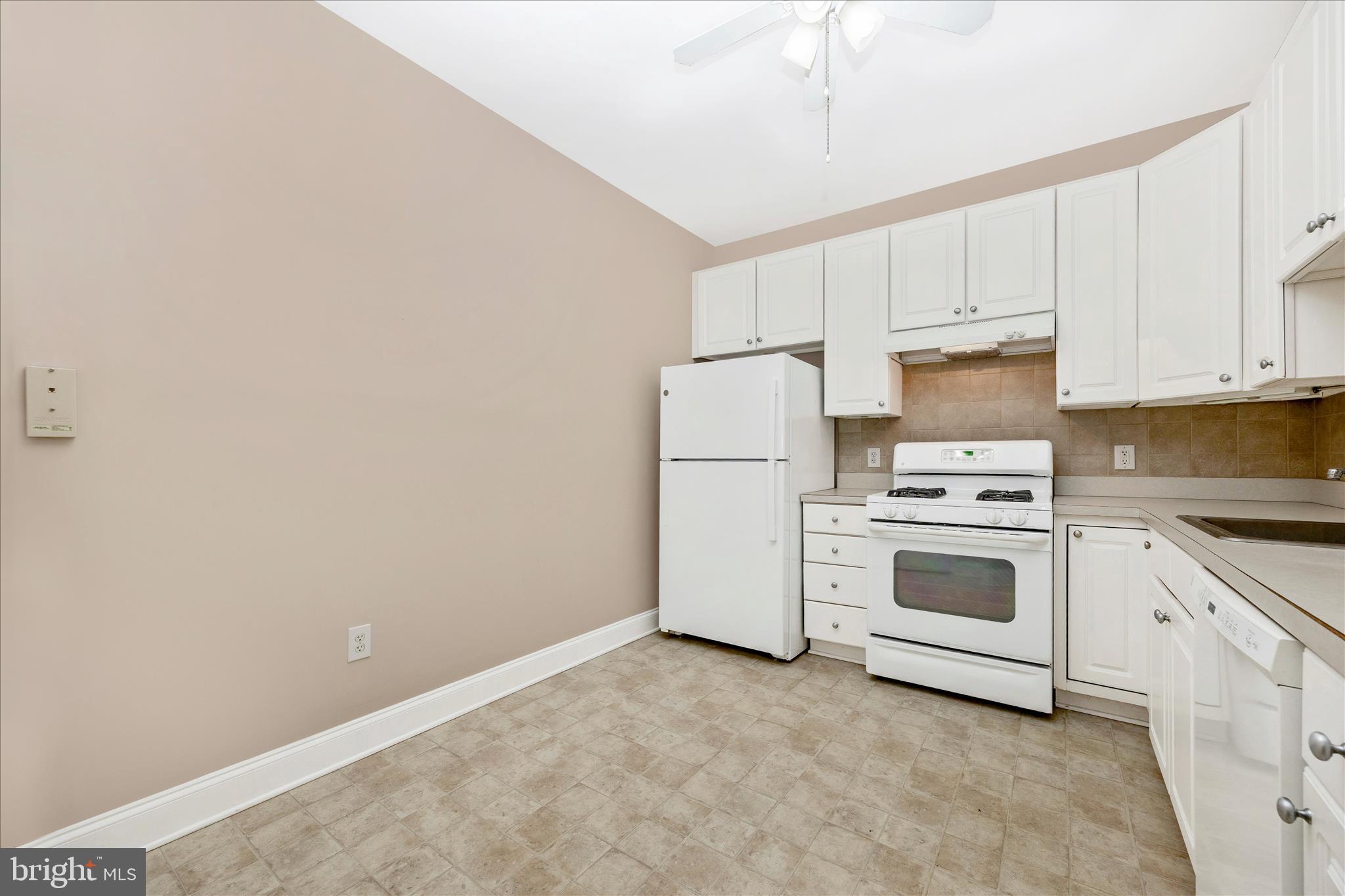2250 Bear Den Road, Unit 207 Frederick, MD 21701 - Photo 11 of 43 a kitchen with white cabinets and white appliances
