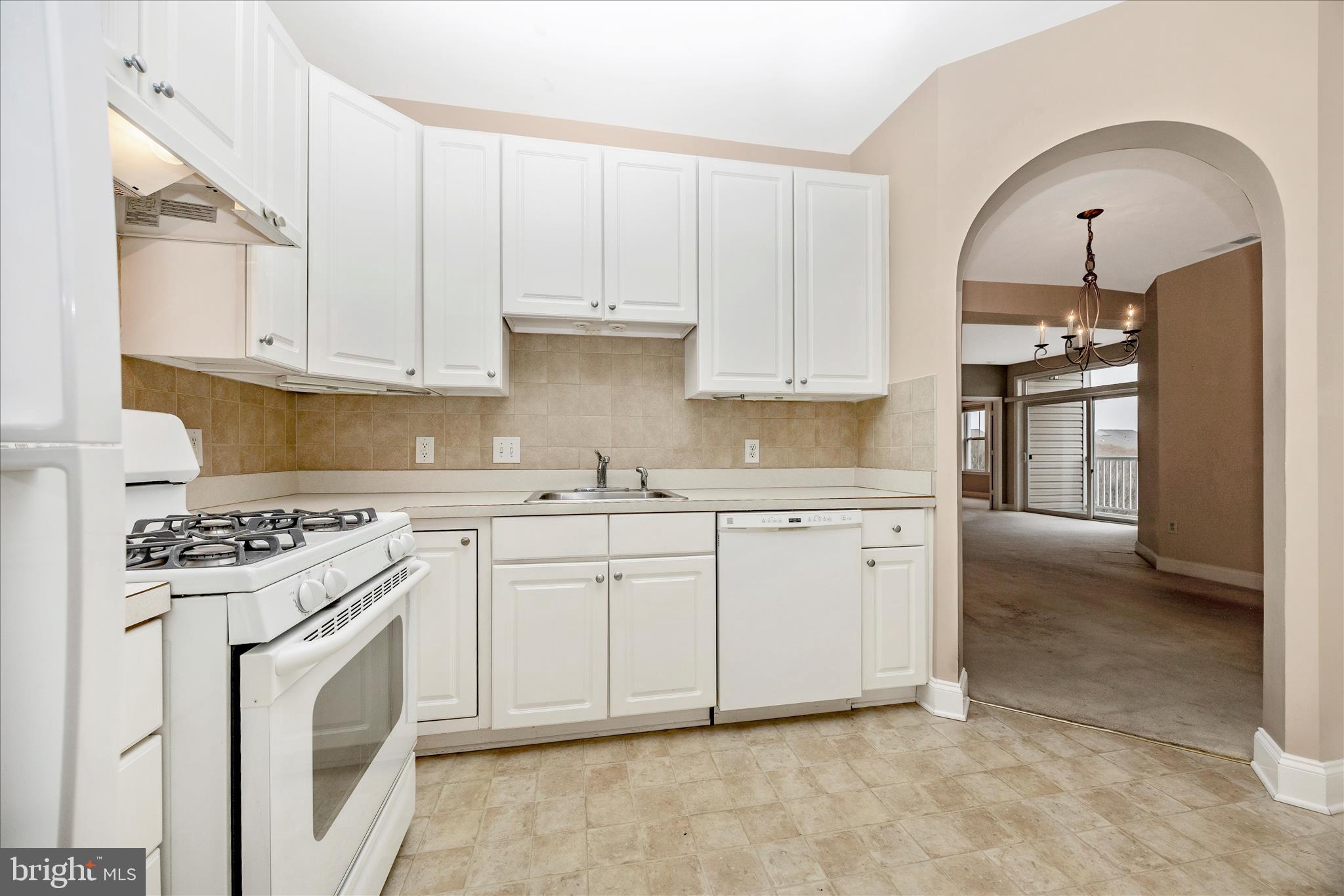 2250 Bear Den Road, Unit 207 Frederick, MD 21701 - Photo 12 of 43 a kitchen with granite countertop white cabinets and white appliances