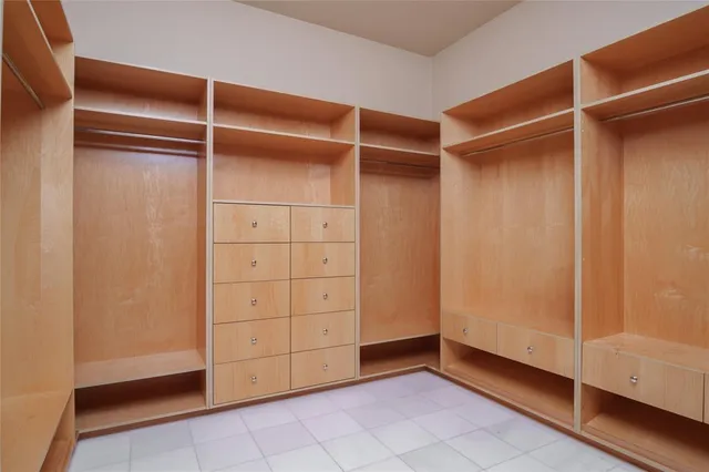 a view of walk in closet with empty racks