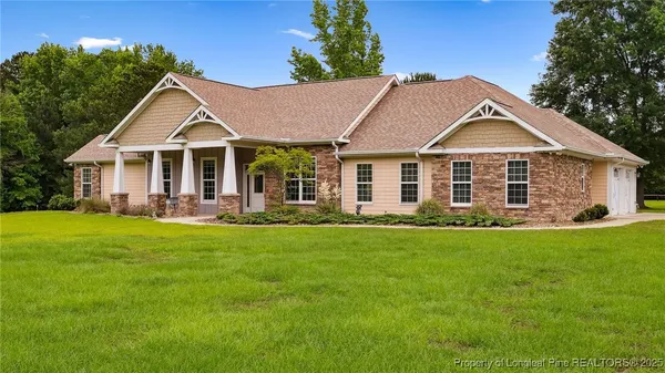a front view of a house with a yard and green space