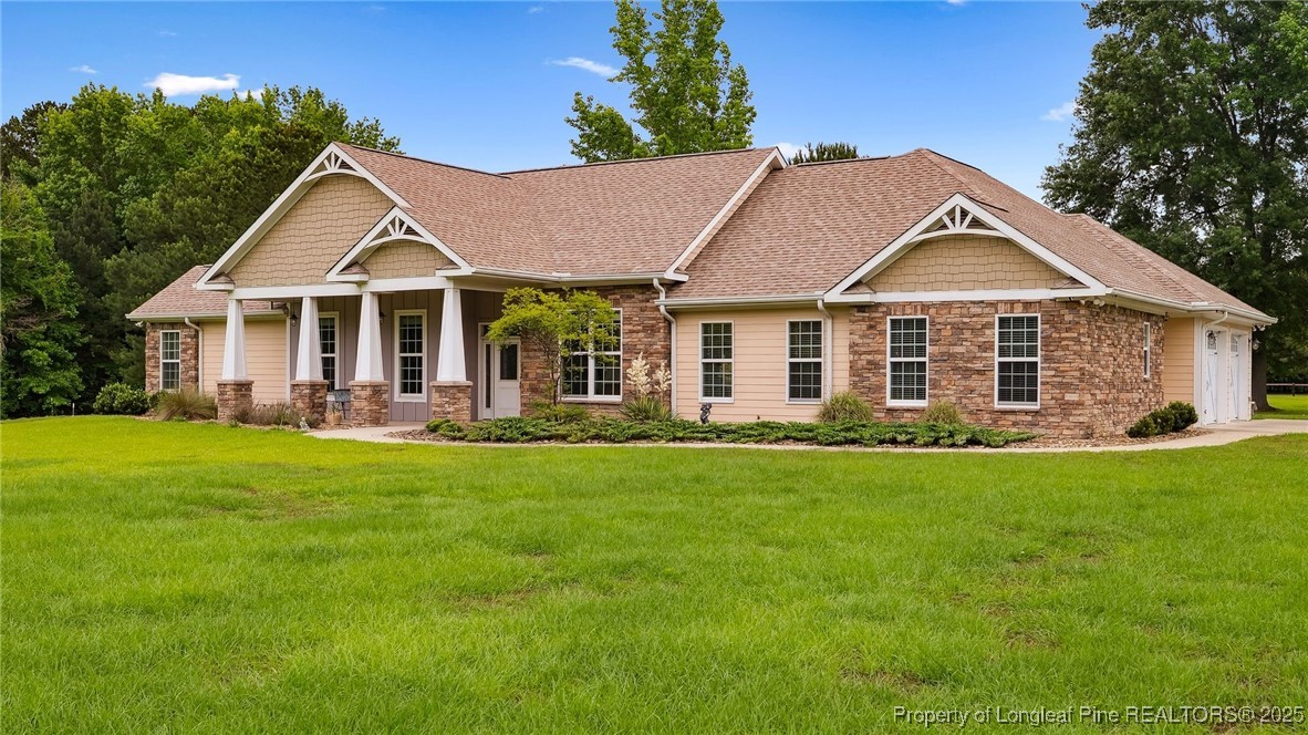 a front view of a house with a yard and green space