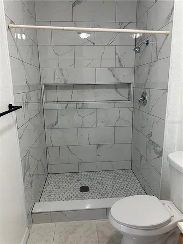 a bathroom with a toilet and a shower