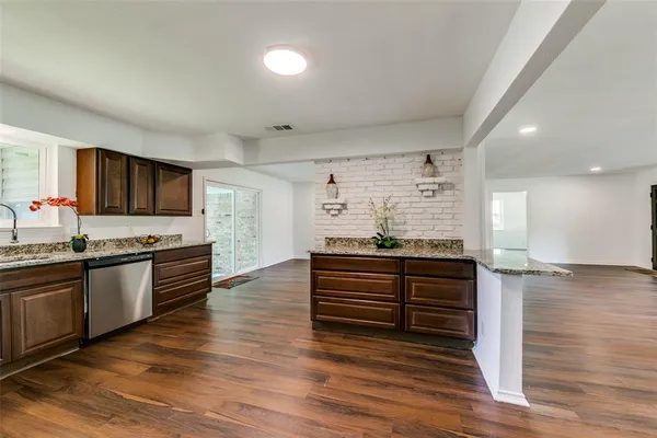 a kitchen with stainless steel appliances granite countertop a stove and a wooden floors