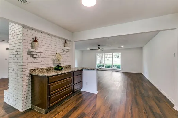 a kitchen that has a stove and a wooden floor