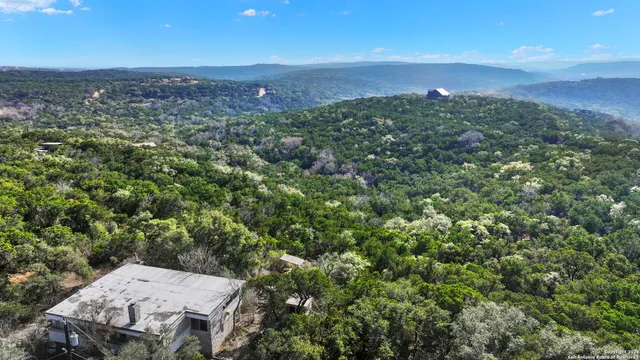 an aerial view of a house with a yard and lake view