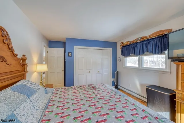 a bedroom with a bed and a refrigerator