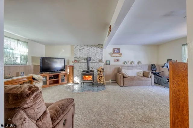a living room with furniture and a flat screen tv with kitchen view