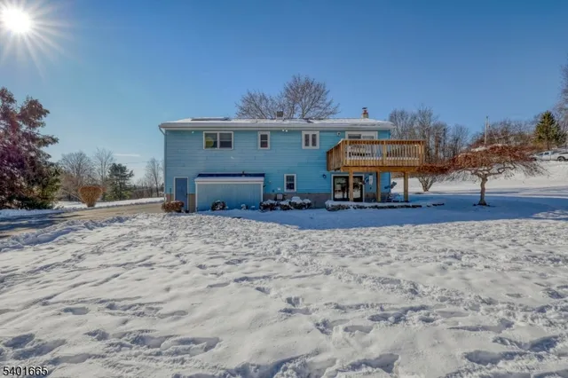 a view of a house with backyard and trees