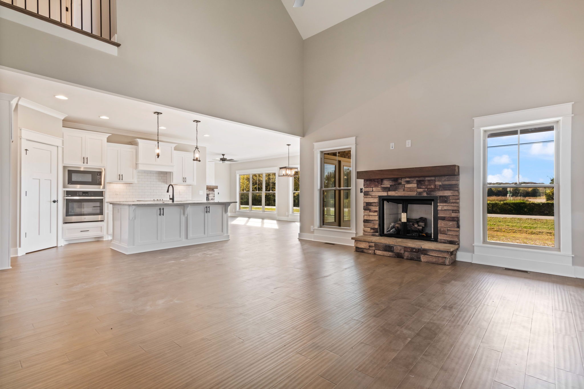 2712 Carousel Drive Murfreesboro, TN 37128 - Photo 10 of 36 an empty room with wooden floor fire place and kitchen view