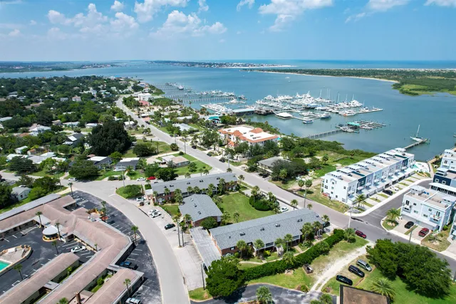 an aerial view of ocean and residential houses with outdoor space