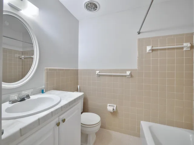 a bathroom with a sink a toilet and mirror