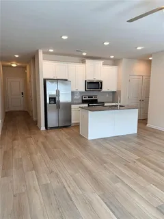 a kitchen with stainless steel appliances a refrigerator sink and microwave