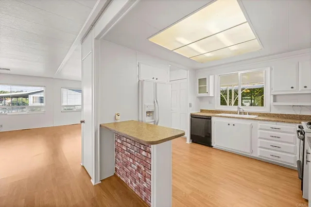 a kitchen with granite countertop a sink cabinets and stainless steel appliances