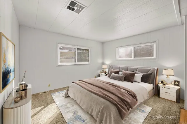 a bedroom with a large bed and a night stand