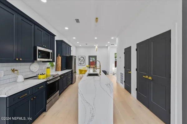 a kitchen with stainless steel appliances a sink counter space cabinets and a window