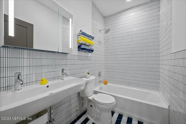 a bathroom with a sink a toilet and bathtub