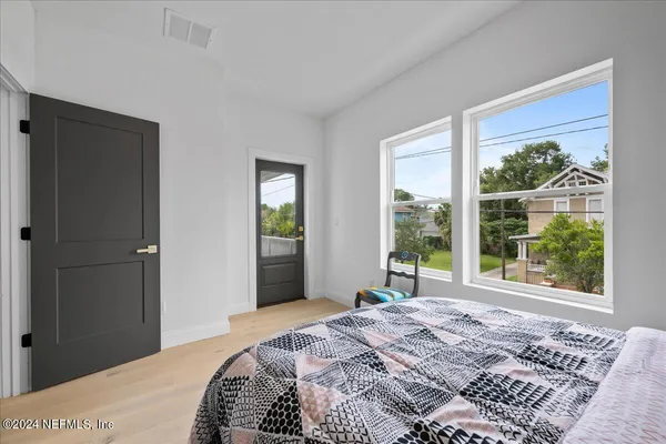 a bedroom with a bed and a large window