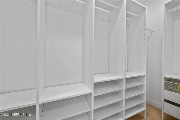 a view of walk in closet with empty racks