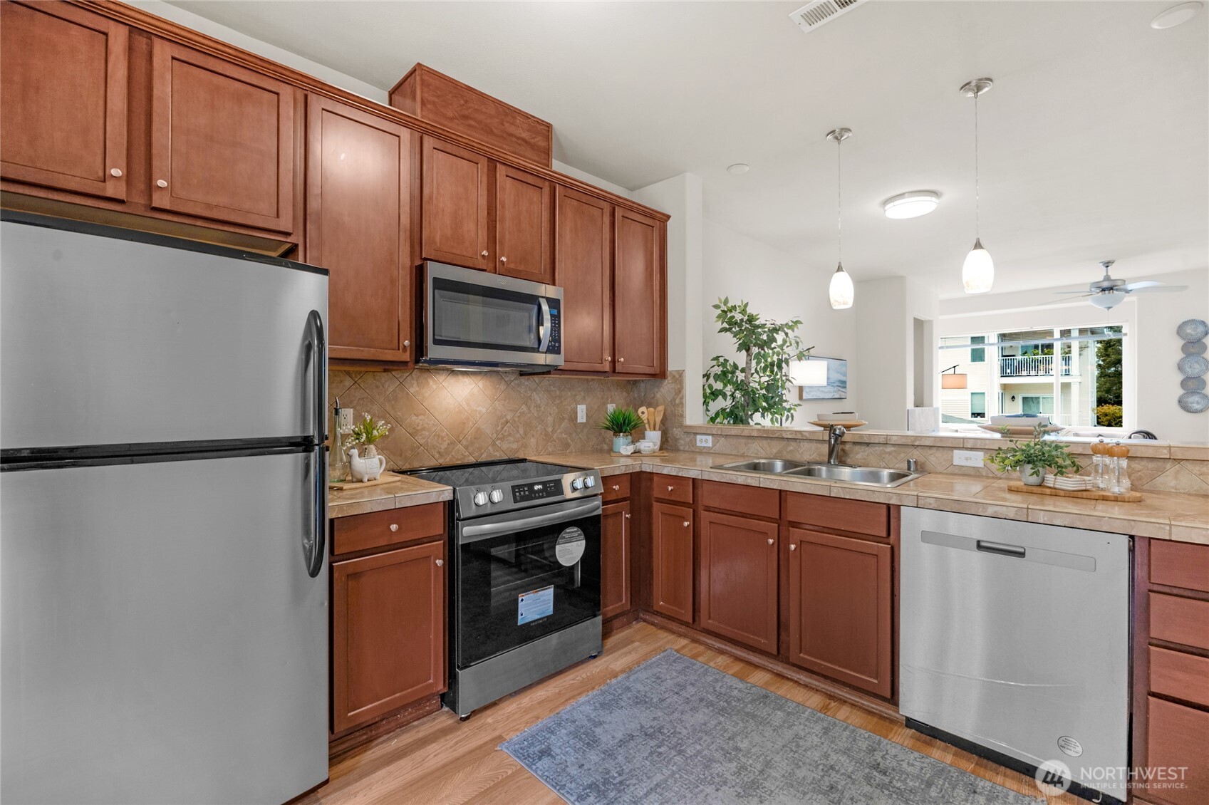 14915 38th Drive Southeast, Unit JJ1180 Bothell, WA 98012 - Photo 14 of 38 a kitchen with granite countertop a sink stainless steel appliances and cabinets