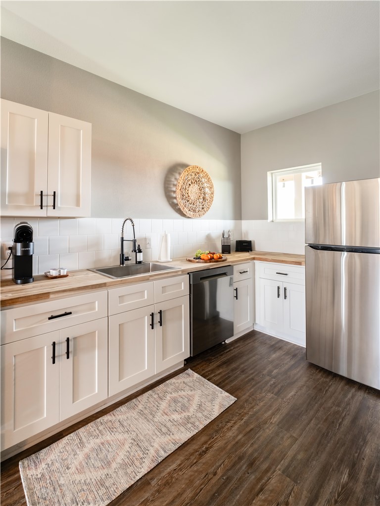 101 West 33rd Street, Unit 103 Bryan, TX 77803 - Photo 4 of 14 a kitchen with a sink white cabinets and stainless steel appliances