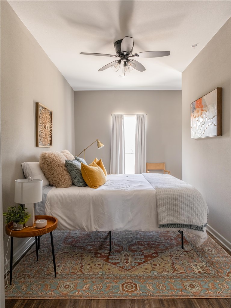 101 West 33rd Street, Unit 103 Bryan, TX 77803 - Photo 10 of 14 a bedroom with a bed and wooden floor