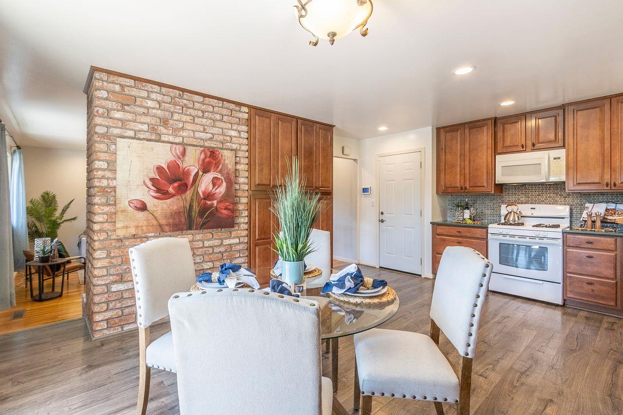 616 Sobrato Drive Campbell, CA 95008 - Photo 11 of 27 a kitchen with stainless steel appliances granite countertop a stove a refrigerator a dining table and chairs with wooden floor