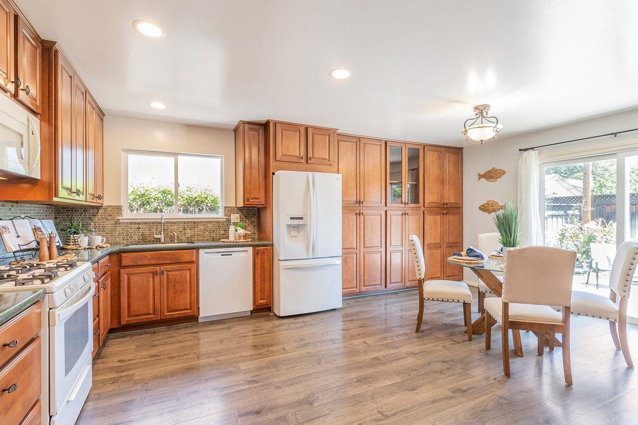 616 Sobrato Drive Campbell, CA 95008 - Photo 14 of 27 a kitchen with stainless steel appliances granite countertop a refrigerator a stove top oven a sink dishwasher and a dining table with wooden floor