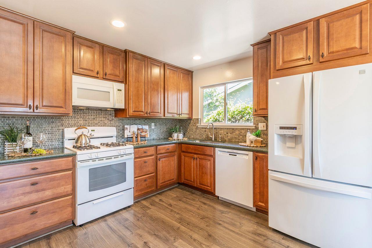 616 Sobrato Drive Campbell, CA 95008 - Photo 15 of 27 a kitchen with stainless steel appliances granite countertop a stove a sink dishwasher and white refrigerator with wooden cabinets