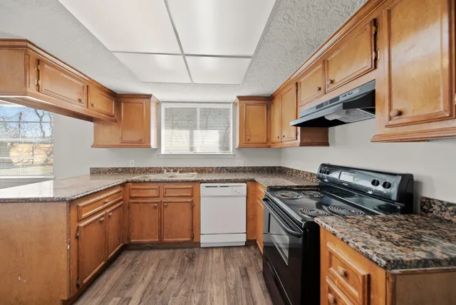 a kitchen with stainless steel appliances granite countertop a stove sink and cabinets