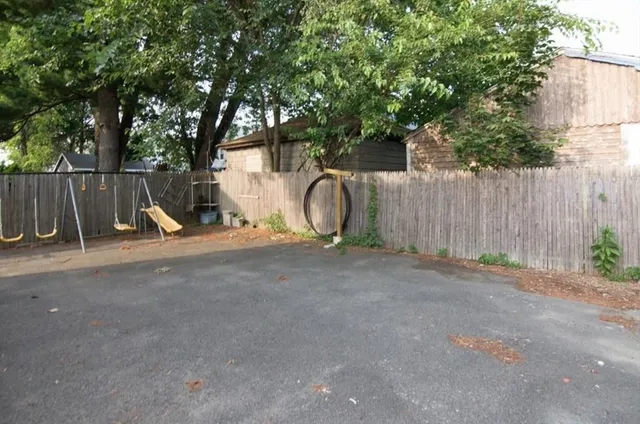 a view of backyard with small cabin and wooden fence
