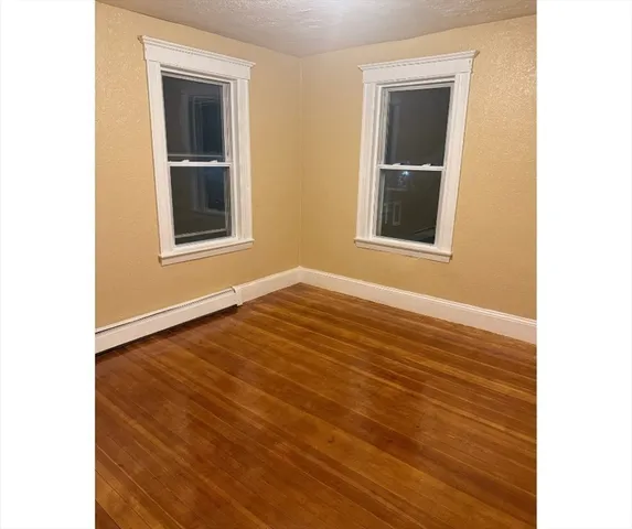 a view of an empty room with closet and a window