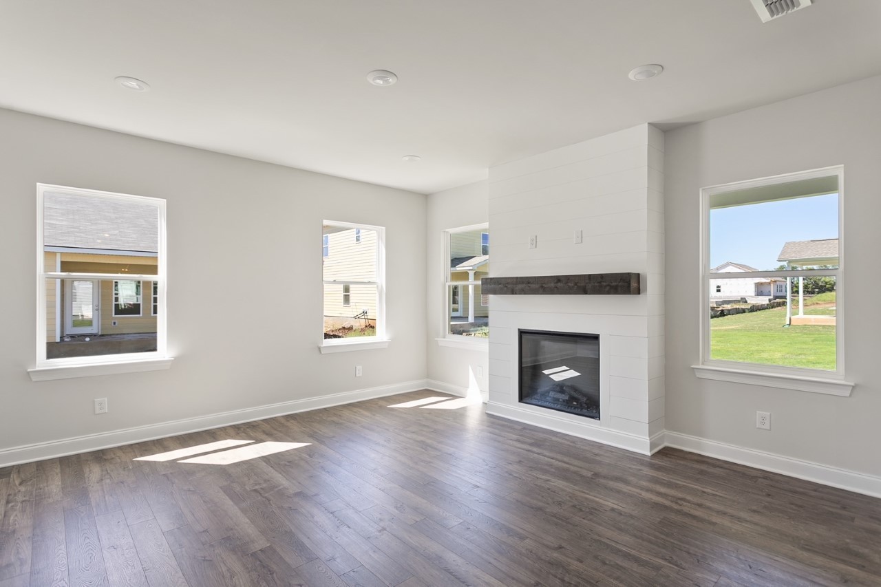 1108 Riverview Run Madison, TN 37115 - Photo 9 of 23 an empty room with wooden floor fireplace and windows