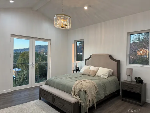 a bedroom with a large bed and a chandelier