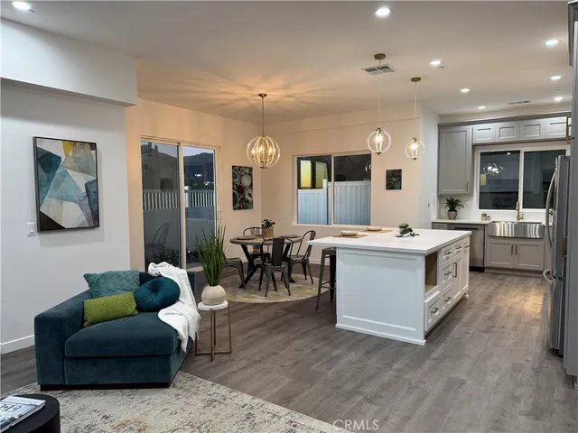 a large white kitchen with a large window and stainless steel appliances
