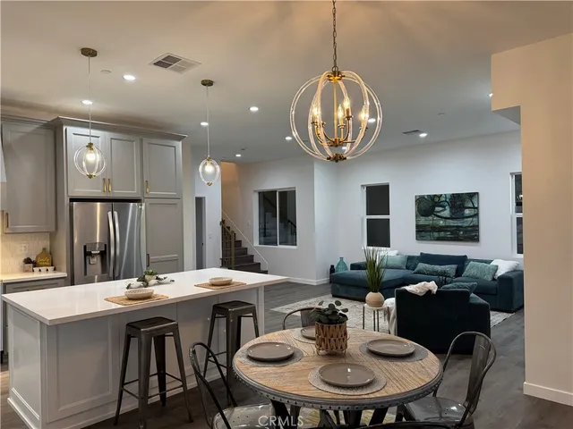 a view of a dining room with furniture a chandelier and wooden floor