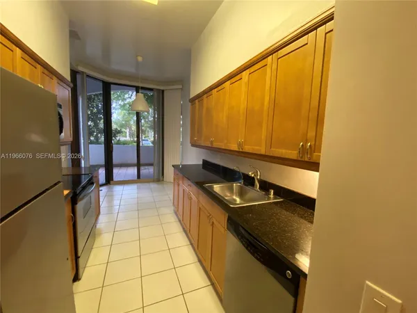 a kitchen with stainless steel appliances granite countertop a sink and a stove