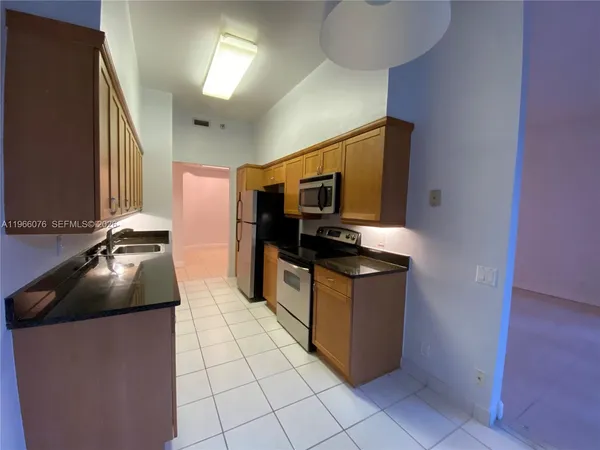 a kitchen with a sink a counter top space and stainless steel appliances