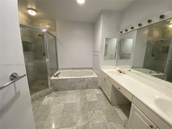 a bathroom with a tub a sink and shower