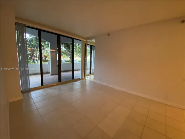 a view of an empty room with closet and a bathroom