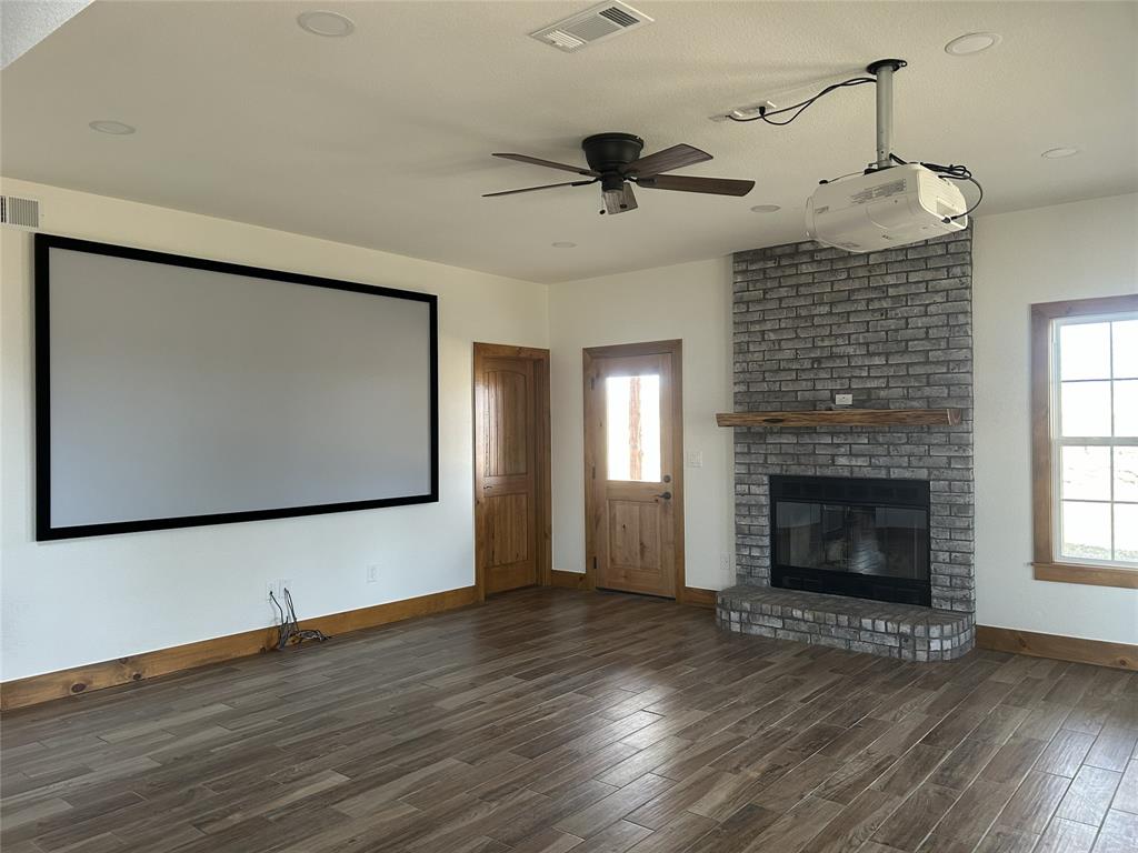 307 County Road 4790 Boyd, TX 76023 - Photo 2 of 25 a view of an empty room with wooden floor fireplace and a window