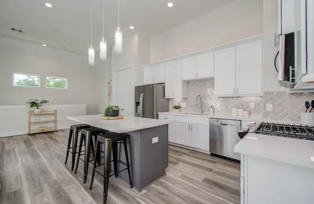 a kitchen with a table chairs microwave and cabinets
