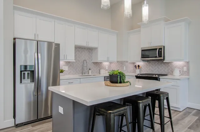 a kitchen with a refrigerator and a stove top oven