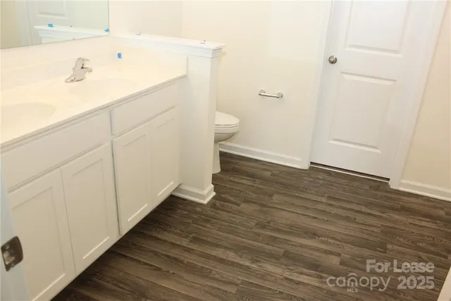 a bathroom with a sink a toilet and a mirror