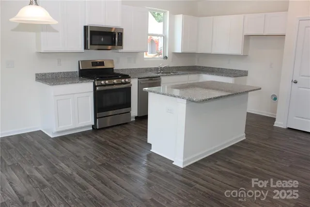 a kitchen with granite countertop a sink and a stove top oven