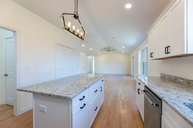 a kitchen with a sink a counter space and wooden floor