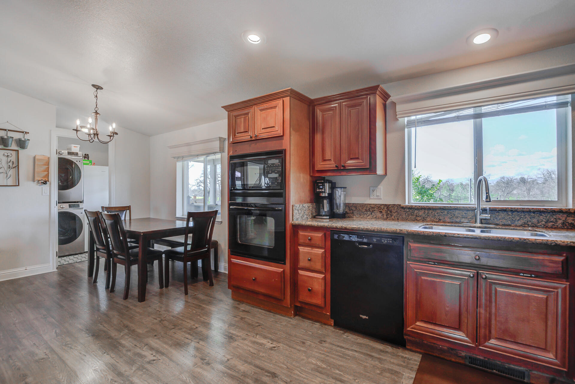 11636 Homestead Lane Redding, CA 96003 - Photo 12 of 37 a kitchen with stainless steel appliances granite countertop a stove top oven a sink dishwasher a dining table and chairs with wooden floor