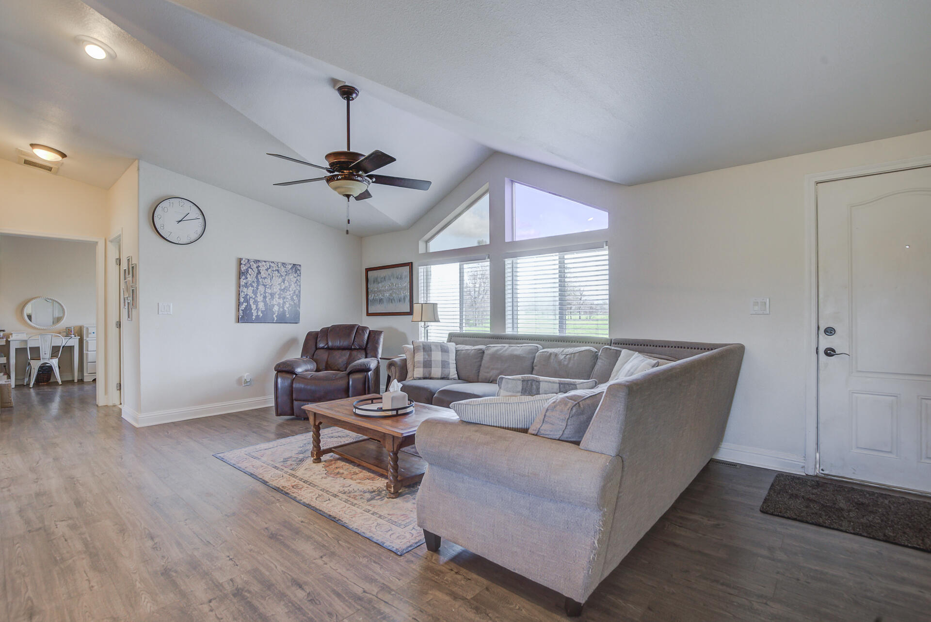 11636 Homestead Lane Redding, CA 96003 - Photo 3 of 37 a living room with couches a chandelier and a dining table with wooden floor